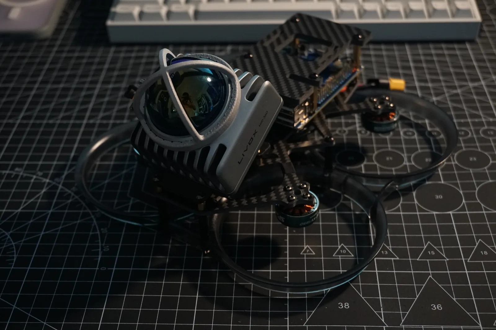 Compact UAV photographed from above, showing the front sensor housing and layered frame